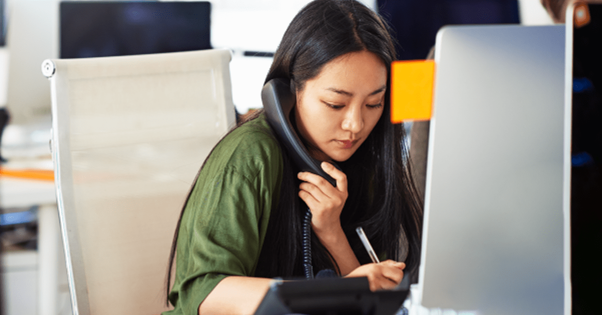 Person on a phone sitting in an office chair in front of a computer using NGP and Donor Target Scores