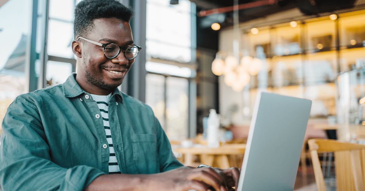 A person is sitting in a cafe on their computer working to improve their campaign's digital presence.