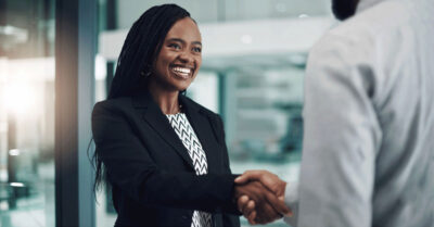 A candidate shakes hands with another person after receiving a political endorsement