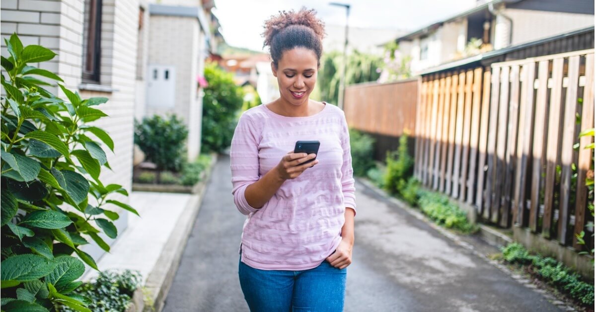 A campaign volunteer looks at their phone while walking during a distributed canvassing campaign.