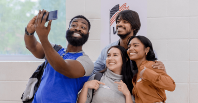 Campaign supporters take a selfie at their polling location to post as a part of their political campaign social media strategy.