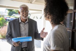 A man follows canvassing dos and don’ts as he talks to a voter in her doorway.