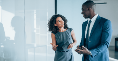 A political campaign manager speaks to a candidate in an office.