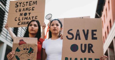 Two women hold signs as they march in a protest during a grassroots political campaign.