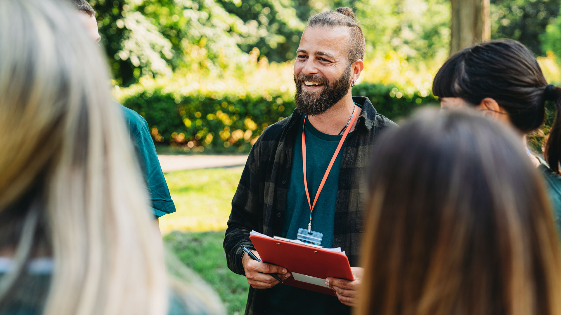 Outdoor organizer holding a clipboard while talking with volunteers before a canvass