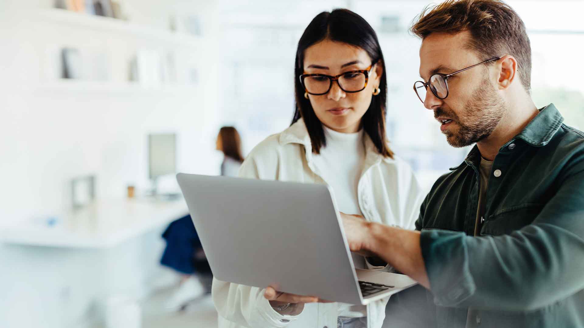 Man and woman standing at a desk, reviewing advocacy data together on a laptop screen.