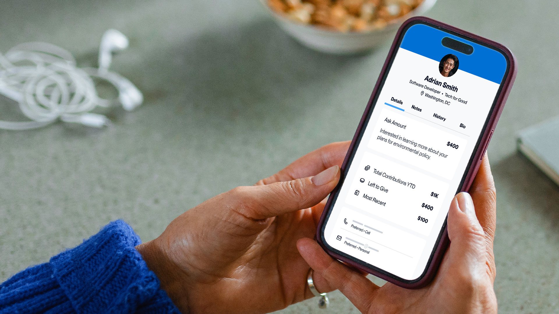 Person holding phone looking at a Call Time Mobile donor record.
