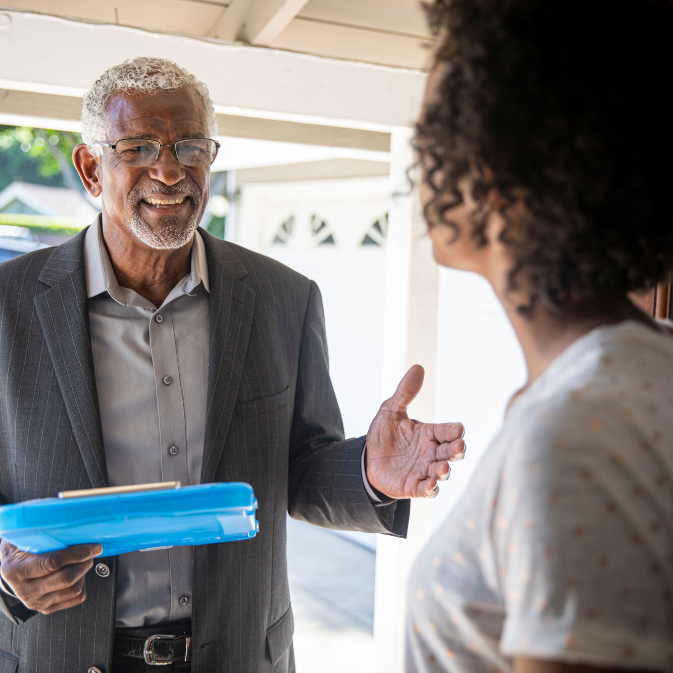 door-to-door canvasser speaking with woman in front of her home