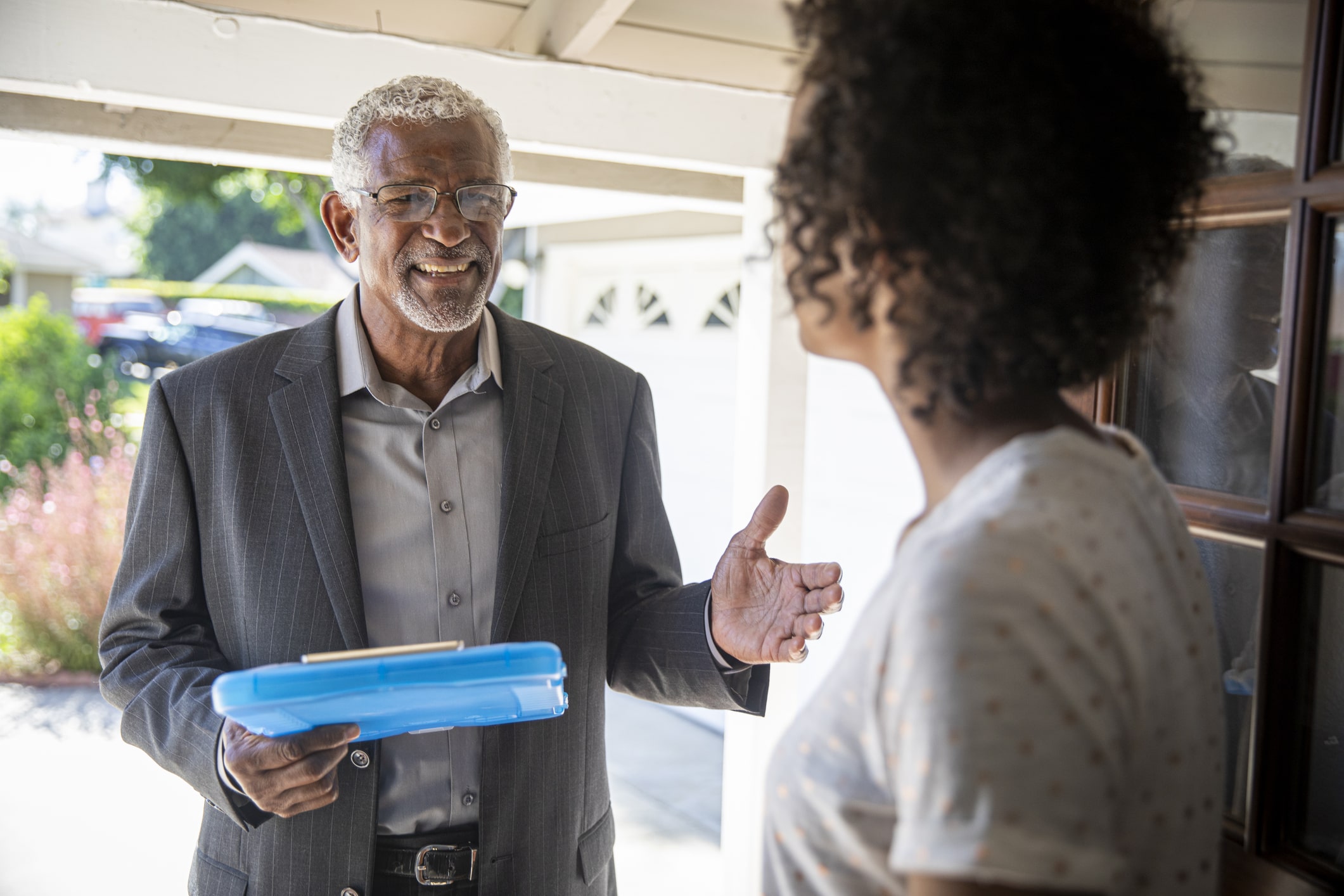 A man follows canvassing dos and don’ts as he talks to a voter in her doorway.