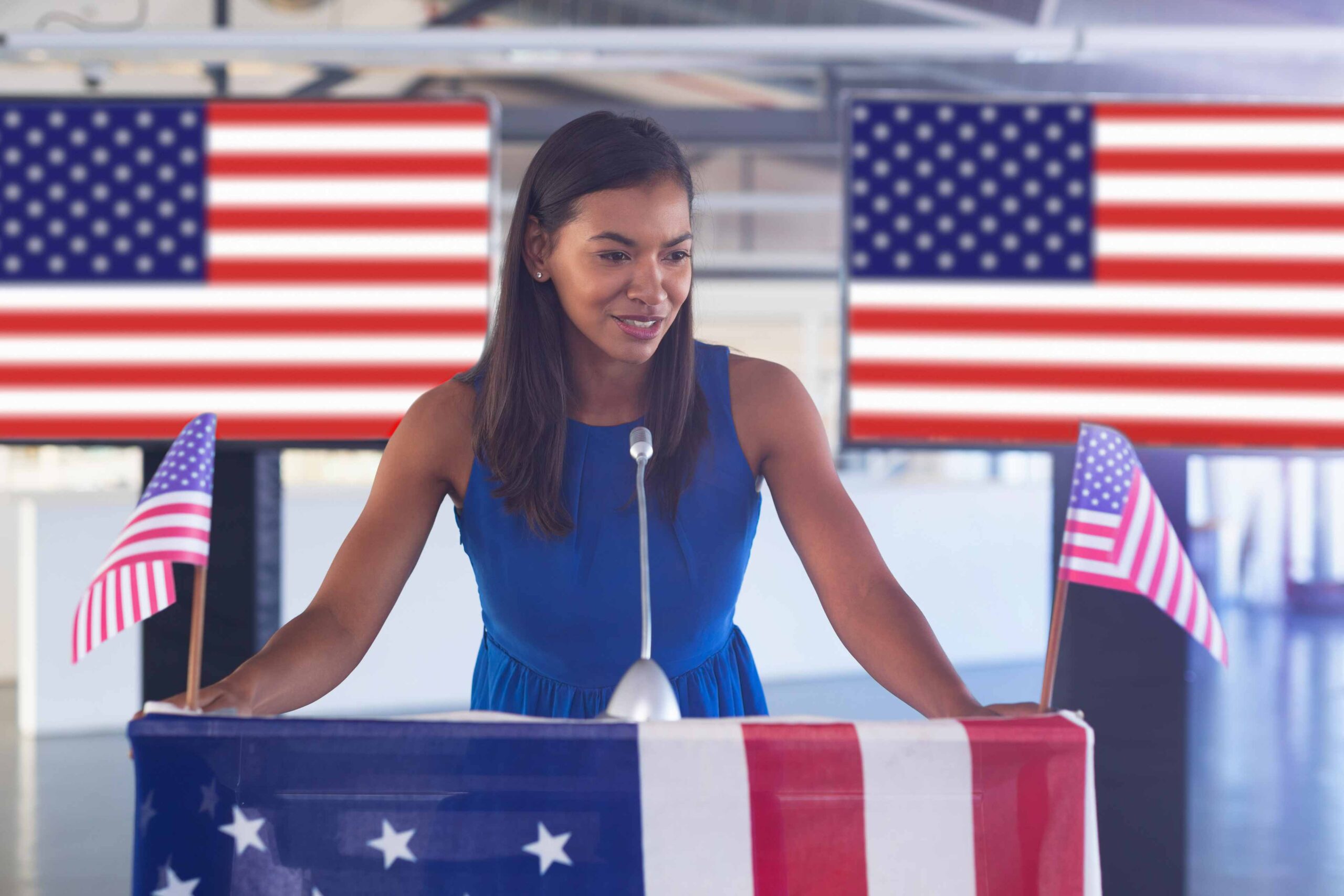 A political candidates at a podium surrounded by American flags