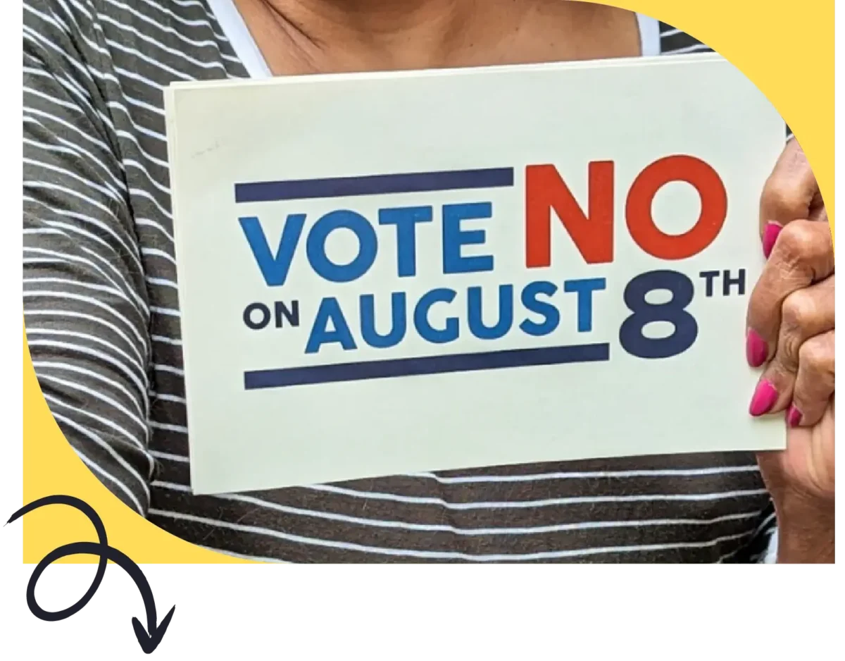 Person at rally holds a vote no on August 8th sign against issue 1 in Ohio special election 2023
