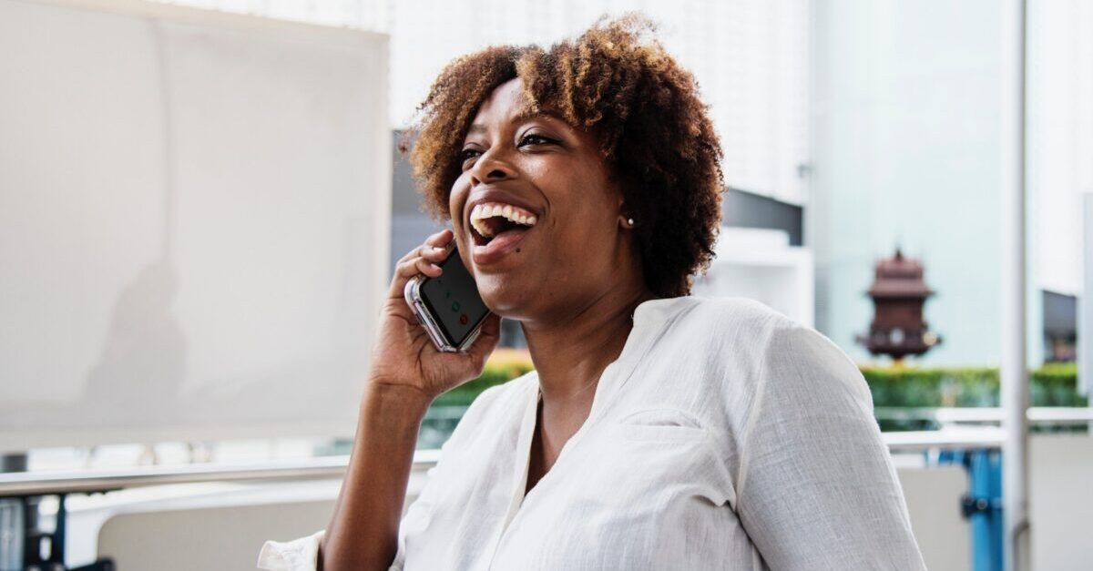 Union member laughing while talking on the phone, engaging in member outreach and workplace organizing.